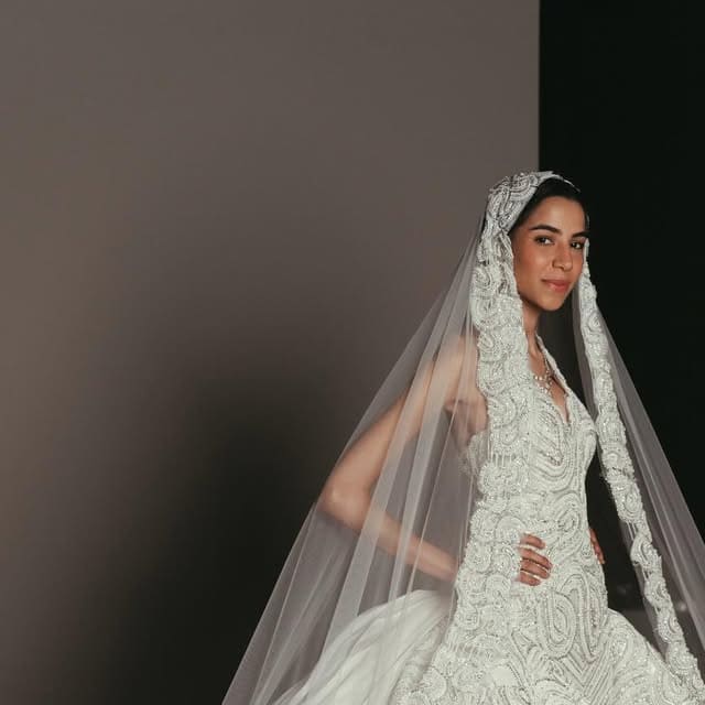 A beaded ivory bridal bodice with sheer veil, photographed in atelier light.