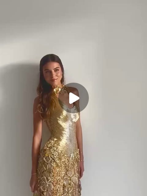 A gold-metallic silk evening dress in low lamplight.
